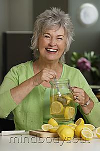 Mind Body Soul - Mature woman making lemon aid.