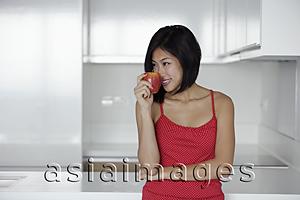 Asia Images Group - young woman smelling red apple