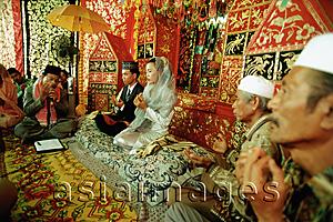 Asia Images Group - Indonesia, a Muslim cleric reading from the Koran to bind bride and groom in marriage.