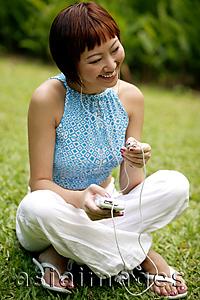 Asia Images Group - Young woman listening to personal stereo