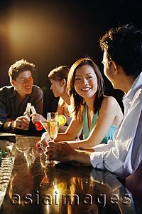 Asia Images Group - Young adults sitting at bar, talking