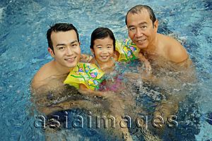 Asia Images Group - Father, grandfather and young girl in a swimming pool, looking at camera