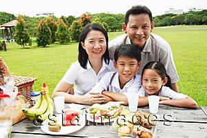Asia Images Group - Family at picnic table, looking at camera, smiling