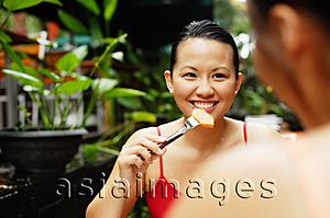 Asia Images Group - Woman eating, facing another person