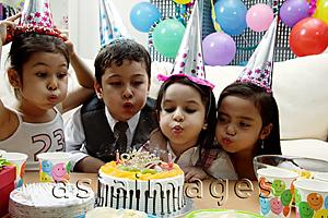 Asia Images Group - Children celebrating birthday, blowing candles on cake