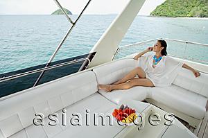 Asia Images Group - Woman sitting on stern of yacht