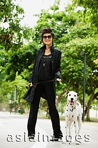 Asia Images Group - Woman dressed in black, with Dalmatian