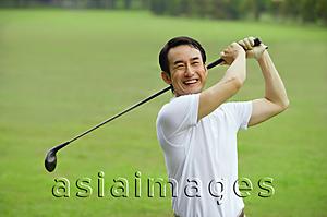 Asia Images Group - Man swinging golf club, smiling at camera