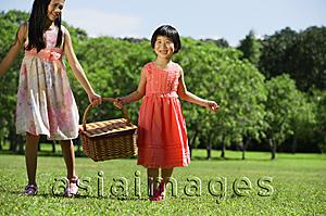 Asia Images Group - Girls in park, carrying picnic basket