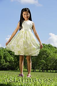 Asia Images Group - Girl wearing dress, standing in park, smiling at camera