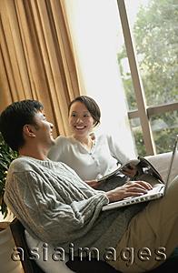 Asia Images Group - Couple in living room, sitting side by side