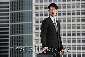 Asia Images Group - Businessman looking at camera, holding briefcase