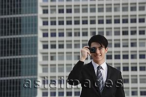 Asia Images Group - Businessman using camera phone