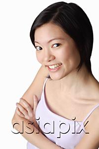 AsiaPix - Young woman looking at camera, smiling, arms crossed