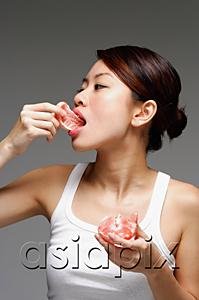 AsiaPix - Woman eating an orange
