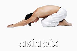 AsiaPix - Man kneeling on floor, doing yoga