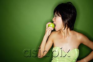 AsiaPix - Woman biting into green apple, side view
