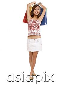 AsiaPix - Young woman carrying shopping bags, smiling