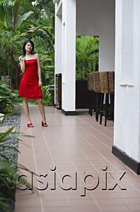 AsiaPix - Woman in red dress, standing outside building