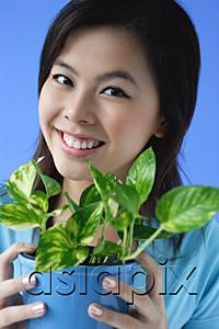 AsiaPix - Young woman holding plant pot