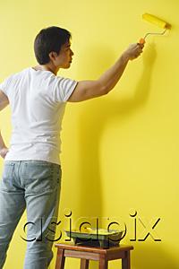 AsiaPix - Man painting wall with yellow paint