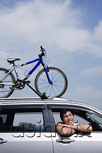 AsiaPix - Man sitting in car, leaning out of window, bicycle on the roof of car