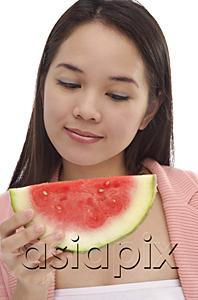 AsiaPix - Young woman looking at slice of watermelon