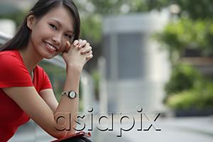 AsiaPix - Young woman smiling at camera, hands clasped