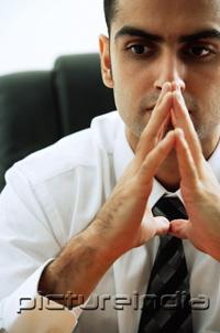 PictureIndia - Businessman with hands together, looking away