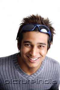 PictureIndia - Man with sunglasses on head, smiling at camera